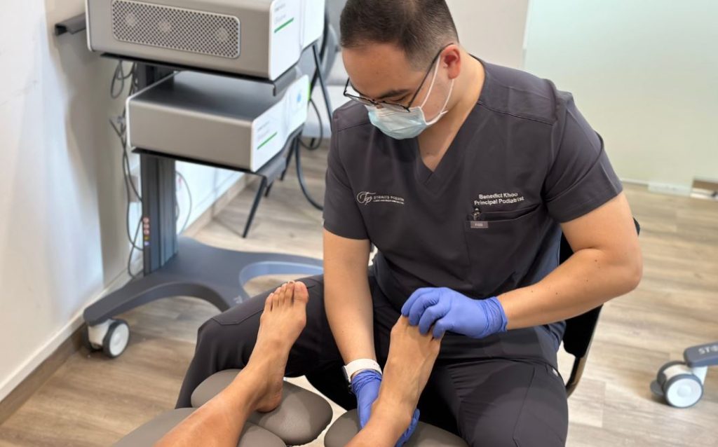 Heel pain treatment in Singapore. Photo showing podiatrist at Straits podiatry providing treatment for heel pain to a patient in Singapore.
